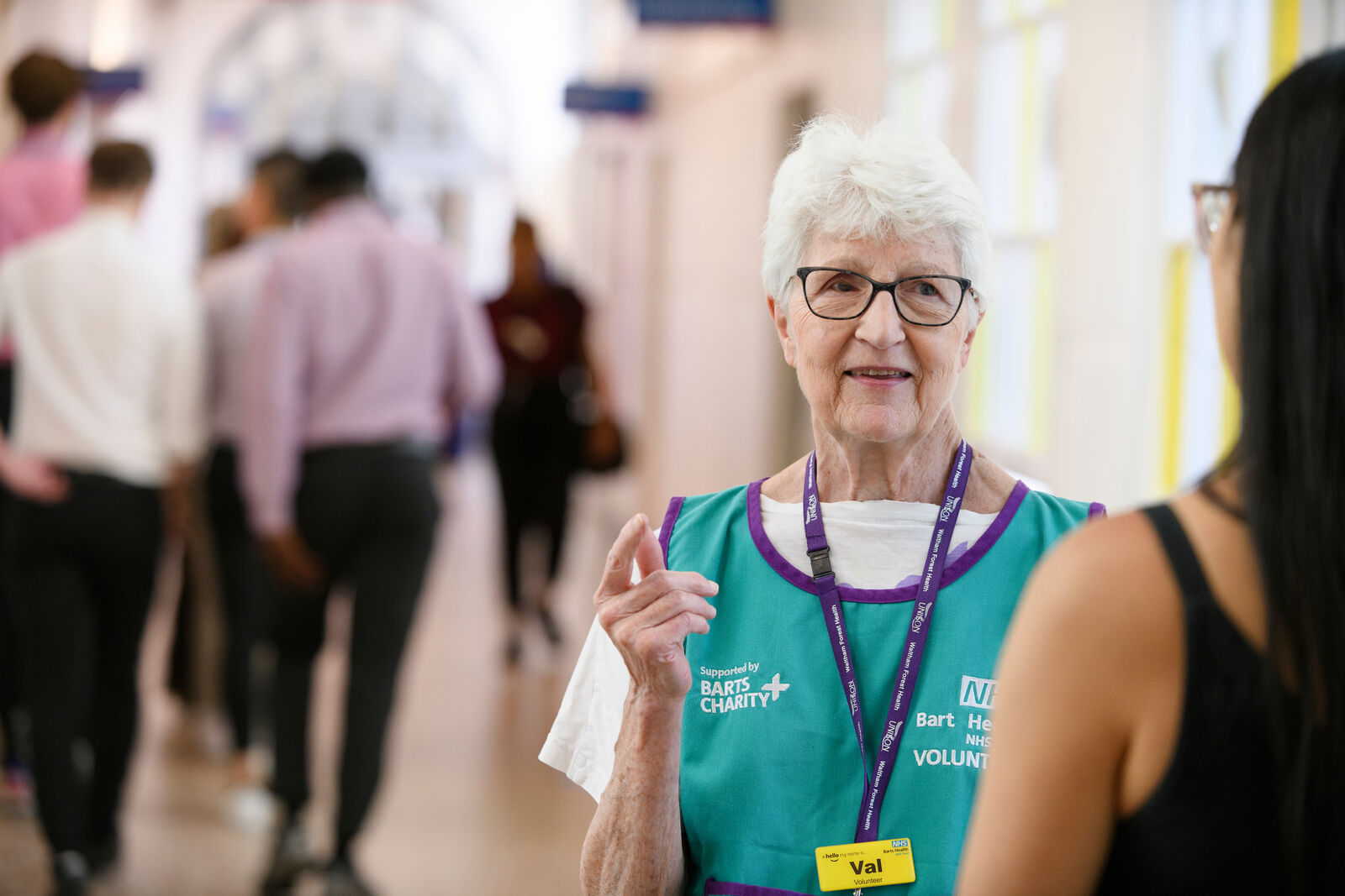 Barts Health volunteer talking to patient in corridor
