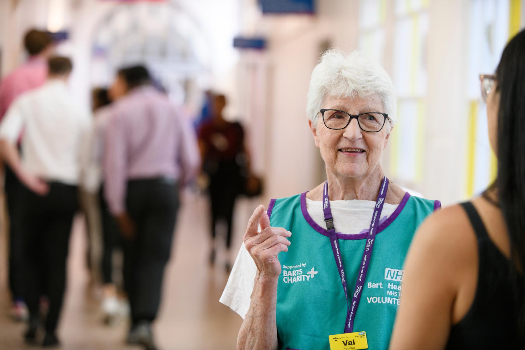 Volunteer Val speaks to a patient at Whipps Cross Hospital