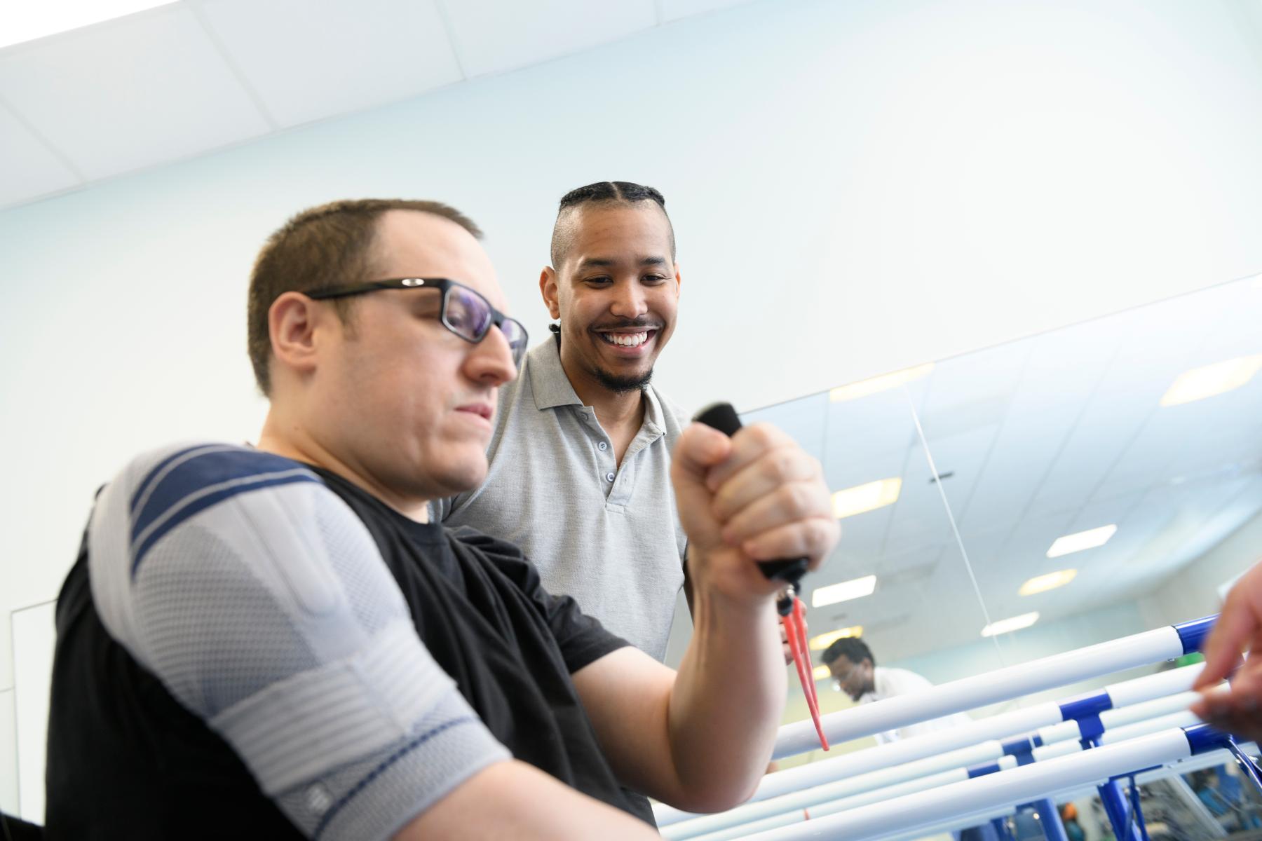 A male patient receives physiotherapy from a healthcare professional