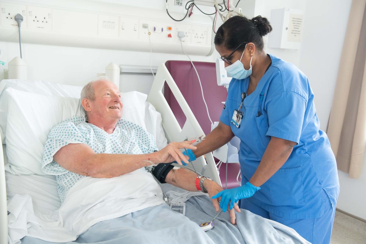 A nurse helping a patient in bed