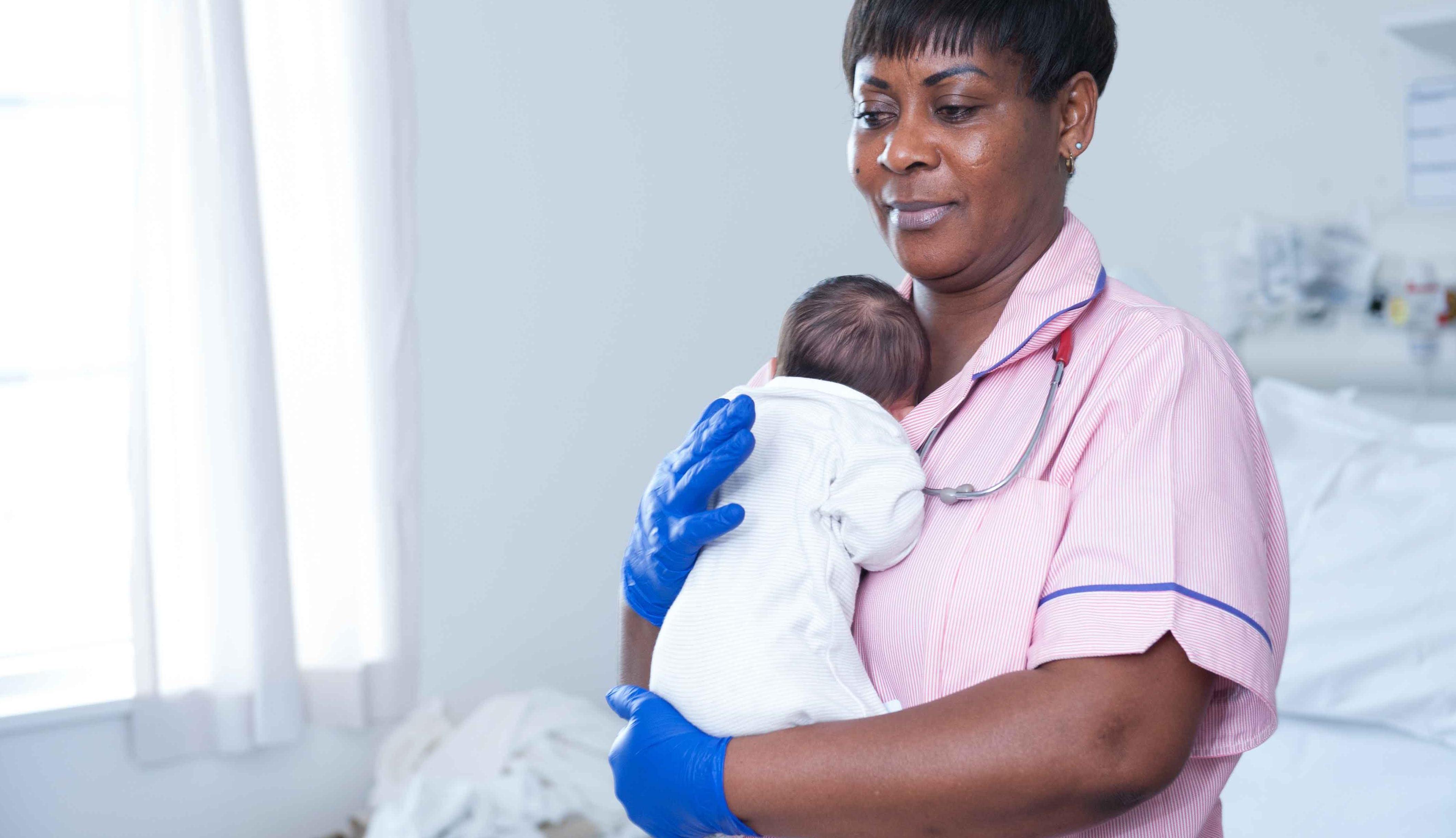 Midwife holding newborn baby