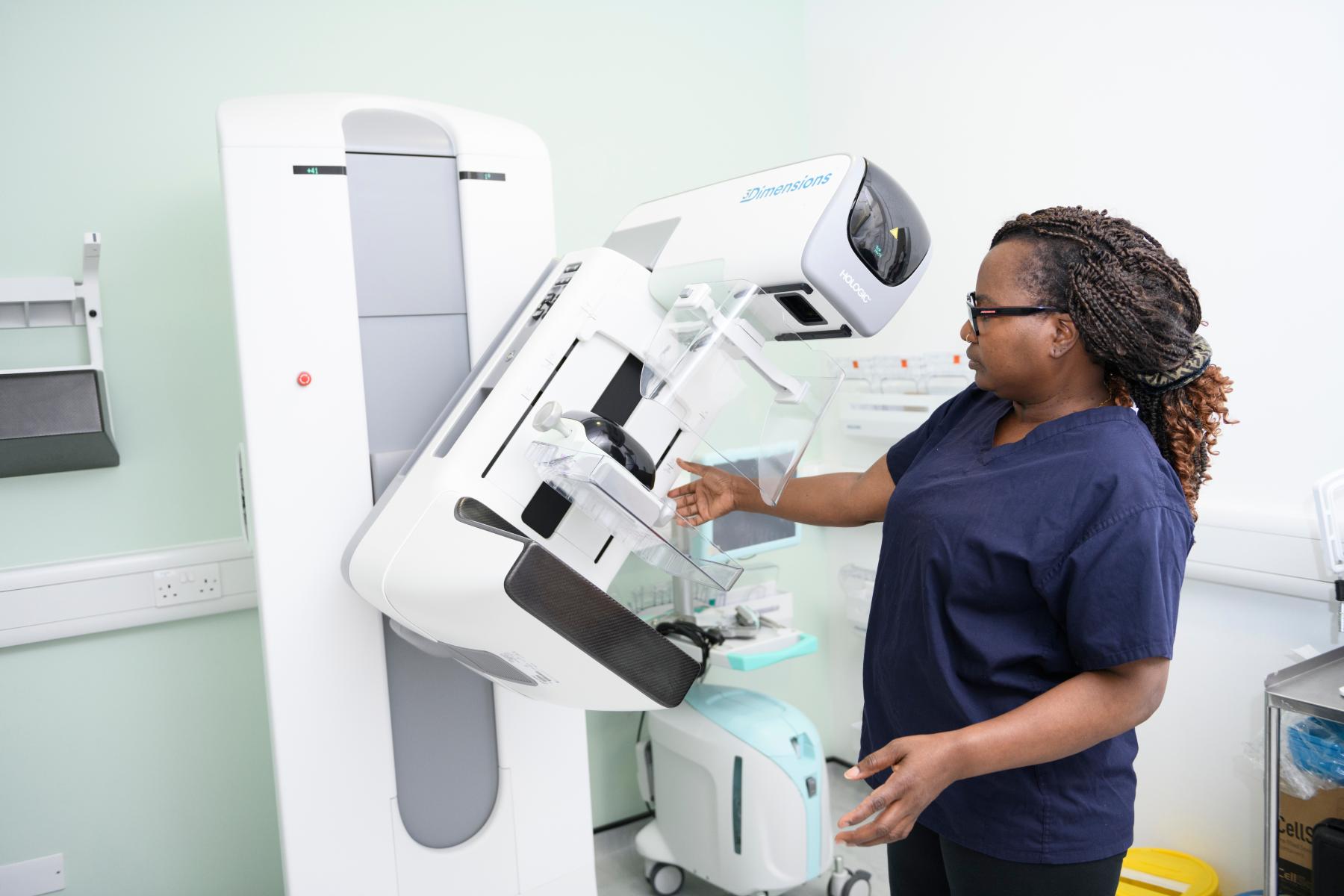 Female member of staff using mammogram machine