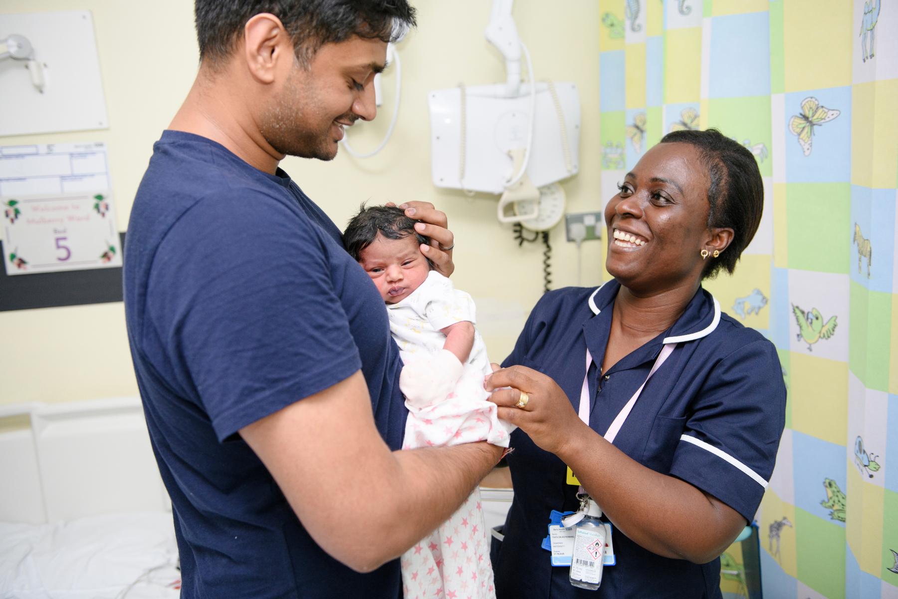 A new parent smiles with a nurse