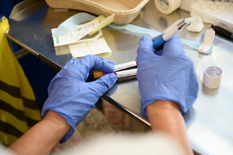 Person writing on blood test tube